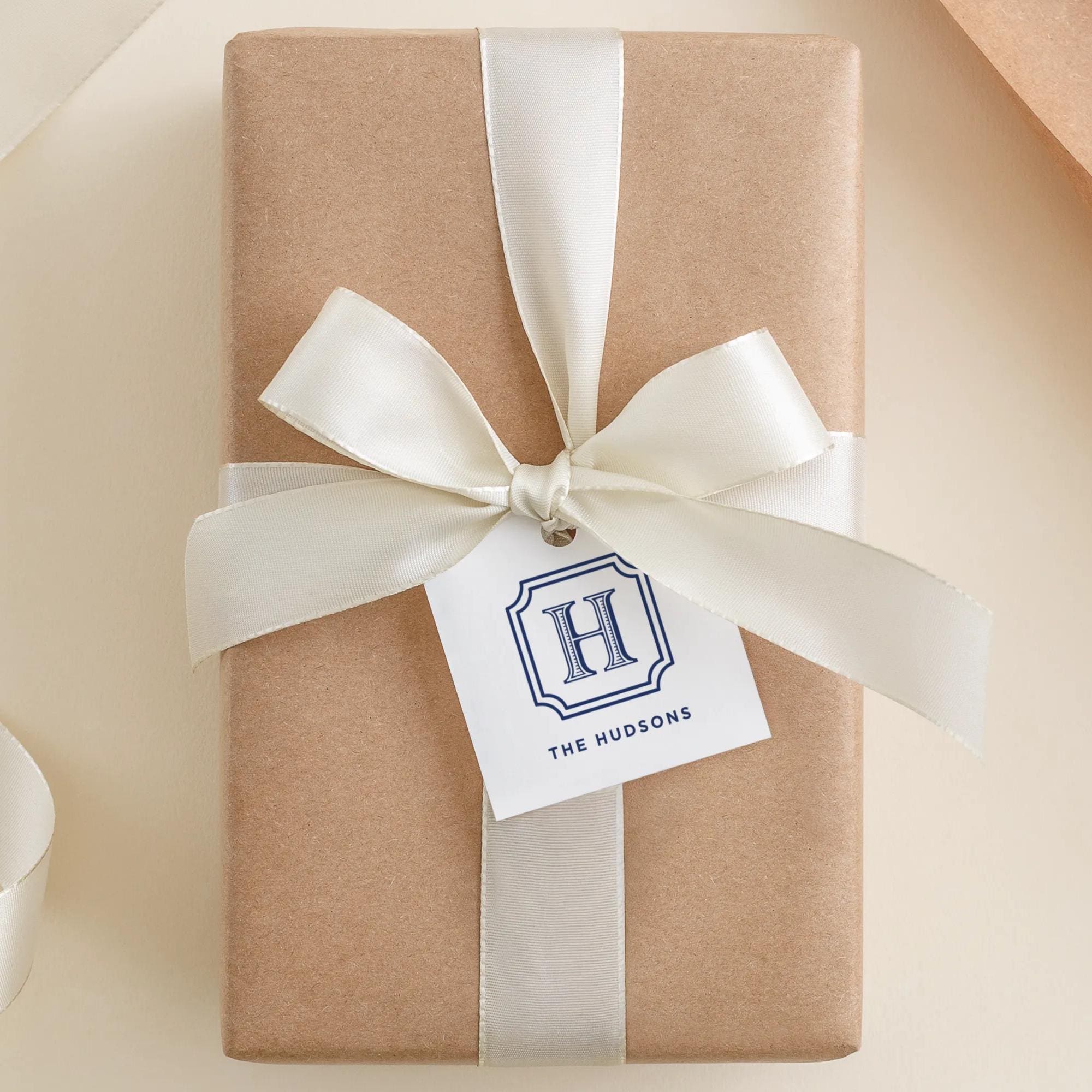 A brown gift box with a white ribbon and a tag that reads "The Huddersons".